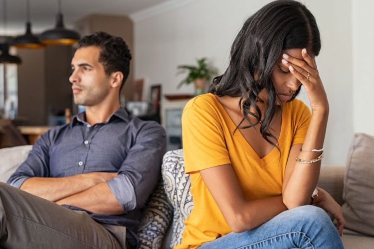 A woman and man don't look at each other on the couch