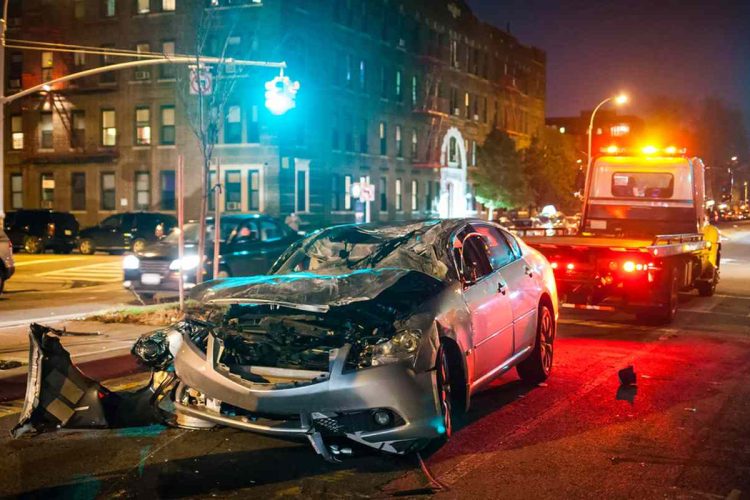 A car accident at night with a tow truck in the background